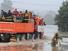 Záchranái projídjí zaplavenou ulicí v Jeseníku nad Odrou. 