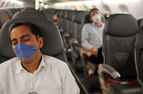 Cestující v letadle pouívají ochranné rouky.