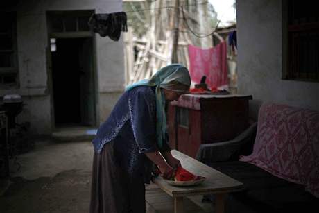 Ujgurská ena pipravuje ve svém dom jídlo.