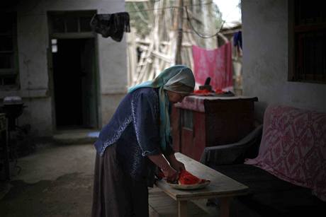 Ujgurská žena připravuje ve svém domě jídlo.