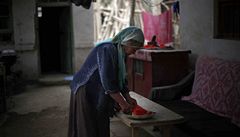 Ujgurská ena pipravuje ve svém dom jídlo.