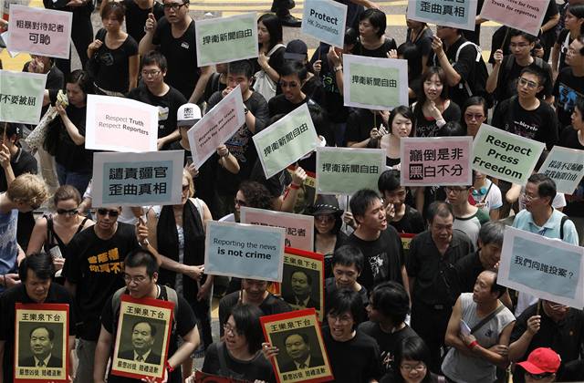Asi sedm stovek noviná�� oble�ených v �erném po�ádalo protestní pr�vod proti zásahu policie proti t�em hongkongským noviná��m v provincii Sin-�iang.