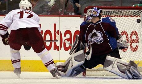 Radim Vrbata (17) z Phoenixu pehrává brankáe Colorada Avalanche Petera Budaje. 