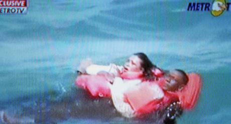 Zábr z indonéské televize ukazuje dva pasaéry trajektu, kteí na oteveném moi ekají na pomoc záchraná