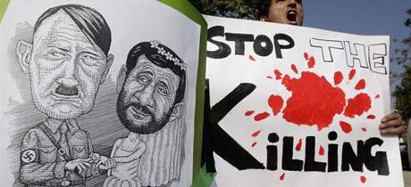 Íránec na demonstraci s plakátem Ahmadíneáda a Hitlera.