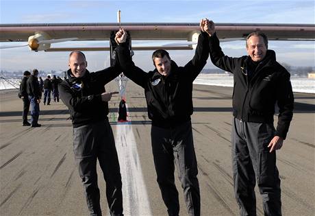 výcarský vdec a dobrodruh Bertrand Piccard (vlevo), zkuební pilot Markus Scherdel (uprosted) a kopilot Andre Borschberg (vlevo) slaví první let solárního letounu. 
