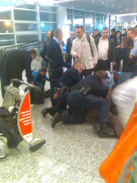 Nmetí policisté zatýkají Jiího Jodase, jeho dcera (vpravo v tmavém) se tomu snaí zabránit - frankfurtské letit 21. prosince 2009 (omluvte, prosím, sníenou kvalitu snímku).