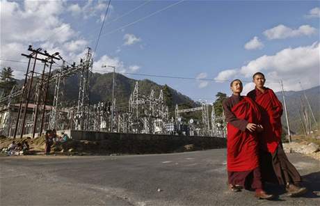 Buddhist monks walk past a power station in the capital Thimphu November 15, 2009. (ilustraní foto)