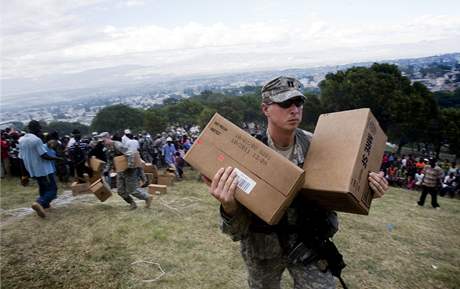 Americký voják pebírá humanitární pomoc shozenou z vrtulníku.