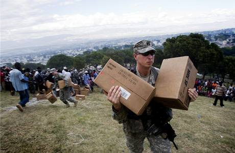 Americký voják pebírá humanitární pomoc shozenou z vrtulníku.