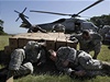 Amerití vojáci schovávají hlavy pi odletu vrtulník, kterými USA dodává humanitární pomoc po ostrov.
