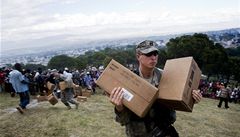 Americký voják pebírá humanitární pomoc shozenou z vrtulníku.