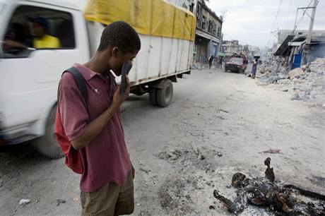 Haian shlíí na spálenou mrtvolu v centru Port-au-Prince.