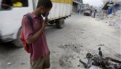 Haian shlíí na spálenou mrtvolu v centru Port-au-Prince.