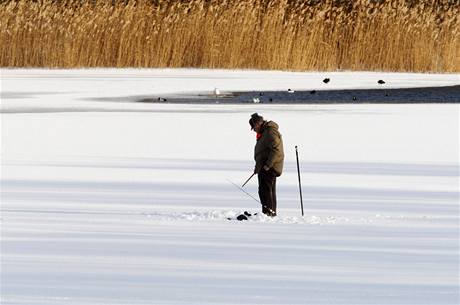 Rybá na zamrzlém jezeru v Nmecku.