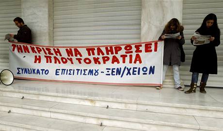Protestující s transparentem "Plutokracie musí zaplatit za krizi" ped hotelem bhem stávky v ecku