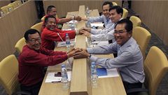 Thajský premiér (vpravo uprosted) Apchisit Vedadíva spolu se svými spolupracovníky potásá rukama Rudým koilím - opozici UDD.