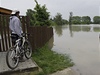 Cyklista sleduje vodu v obci Rohatec na Hodonínsku