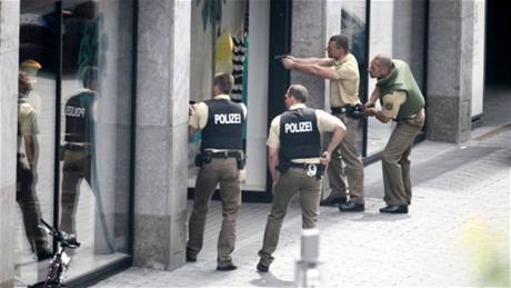 Nmetí policisté ped obchodem, který pepadl ozbrojený mu