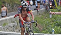 Cyklista Lance Armstrong při stoupání na legendárné Tourmalet. Jeden z postávajících fanoušků mu nabízí vodu 