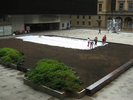 Dělníci na prostranství mezi Národním divadlem a Novou scénou instalují trávník.