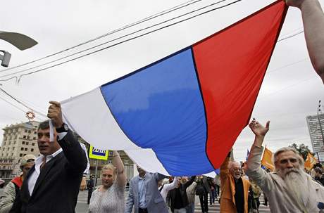 Boris Nmcov a ostatní opoziní aktivisté nesou ruskou vlajku na demonstraci proti vládní garnitue v centru Moskvy