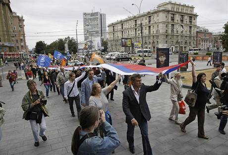Aktivist nesou ruskou vlajku na opozin demonstraci proti vldn garnitue v centru Moskvy