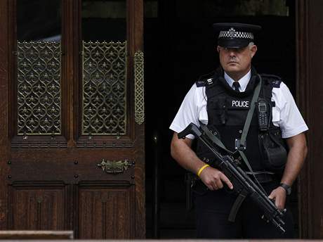 Ozbrojený britský policista hlídá budovu parlamentu.