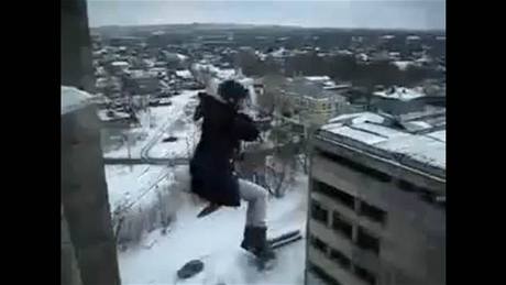 Zábry mladé dívky, která skáe amatérský bungee jumping ze stechy paneláku.