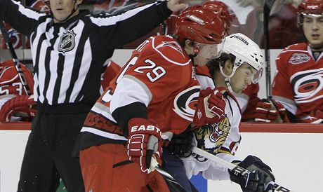 Ryan Carter z Caroliny atakuje eského hokejistu Floridy Michaela Frolíka, který pomohl Panterm dvma asistencemi k výhe v NHL