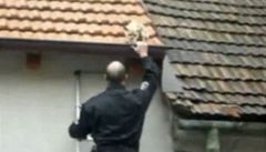 Strá�ník sundavá vystra�enou �ivavu ze st�echy brn�nského domu