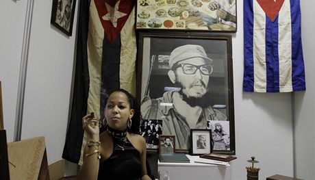 ena kouí doutník ped fotografií Fidela Castra