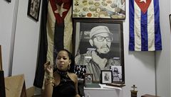 ena kouí doutník ped fotografií Fidela Castra