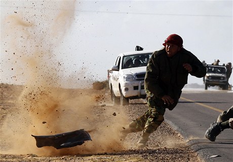 Bojovník z ad povstalc uskakuje ped rapnelem na silnici vedoucí do Bin Davádu. 
