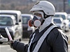 Japonský policista se chrání respirátorem pi evakuaci obyvatel po hávrii v jaderné elektrárn v prefektue Fukuima.