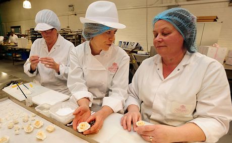 Vyhláená cukráka Fiona Cairnsová (uprosted) s kolegynmi Mary Doodyovou (vpravo) a Dianou Palletovou vyrábjí kvtinové dekorace pro královský svatební dort.