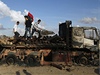 Povstalci prohlíejí zniený náklad zbraní na silnici u Benghází.