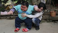 Lu se zvedá z mamin�ina klína. 