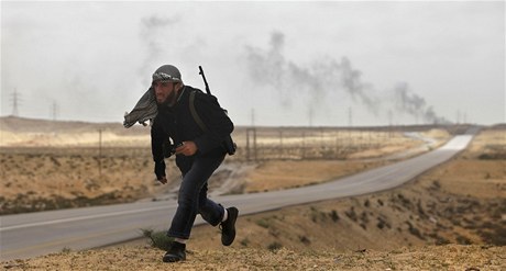 Bojovník z ad povstalc prchá do úkrytu ped ostelováním Kadddáfího sil nedaleko Brigy.  