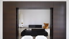 Prhled z jídelny do obývacího pokoje s pvodními kachlovými kamny a keslem od designéra Arne Jacobsena