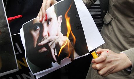 Demonstranti pálí fotografii prezidenta Baára Asada.