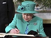 Královna se podepisuje do návtvní knihy v prezidentském paláci. 