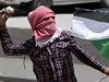Palestinský demonstrant hází kameny na izraelské vojáky na Západním behu.