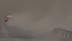 Auto odjí�dí z popelem zasypané m�ste�ku Kirkjubaejarklaustur