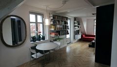 Jídelní kout s asymetrickým stolem a staro�itné zrcadlo.