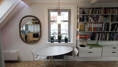 Jídelní kout s asymetrickým stolem a staro�itné zrcadlo.