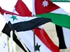 Obyvatelé Jordánska drící syrské a jordánské vlajky