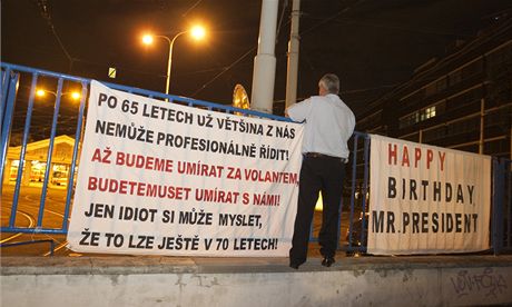 Zamstnanec praského dopravního podniku zavuje transparenty na plot vozovny. Místo se nalo i pro plakát pející prezidentu Václavu Klausovi vechno nejlepí k narozeninám. 