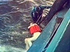 Potáp vytahuje jednu z obtí nedlní tragédie lodi Bulgarija