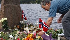 Mu pokládá norskou vlajku na ostrov Utoya k uctní památky obtí.